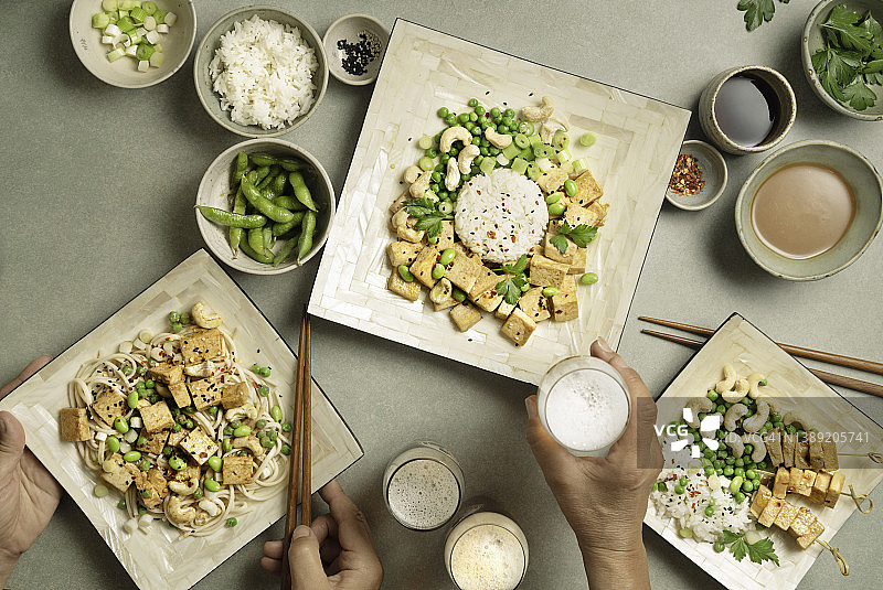餐桌上的各种纯素食品：豆腐、荞麦面、米饭和饮品图片素材
