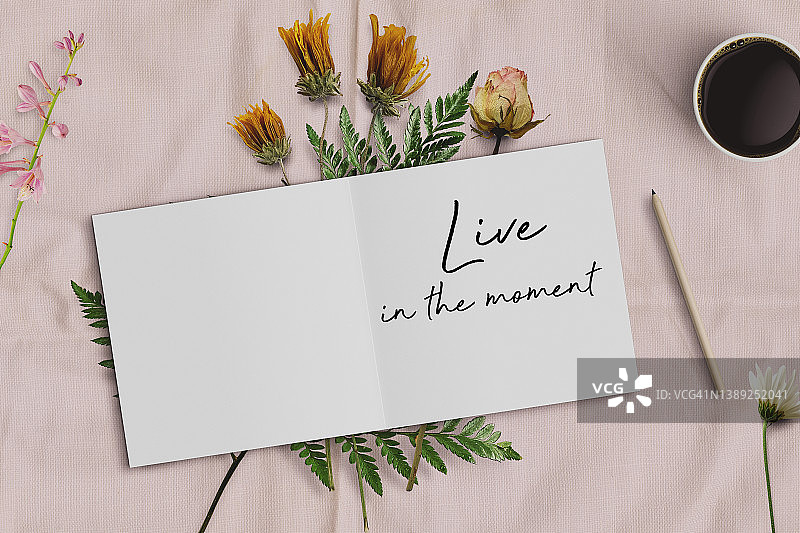 女性桌面，打开的笔记本，鲜花和咖啡杯上的励志语录图片素材