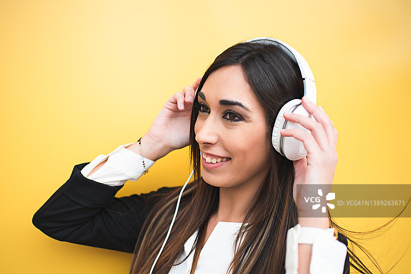 听音乐的女子肖像：戴着耳机在户外听音乐的女子，在隔离背景上听音乐的行政人员特写图片素材