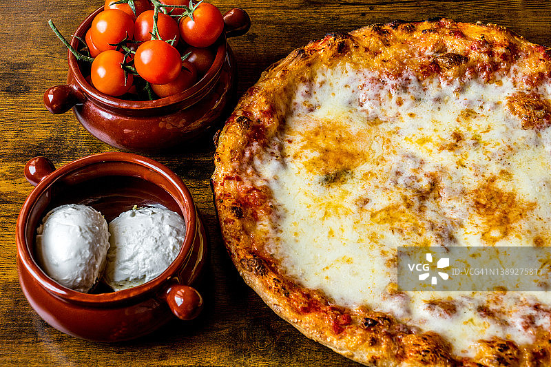 美味完美的意式玛格丽特披萨，配番茄和新鲜马苏里拉奶酪图片素材