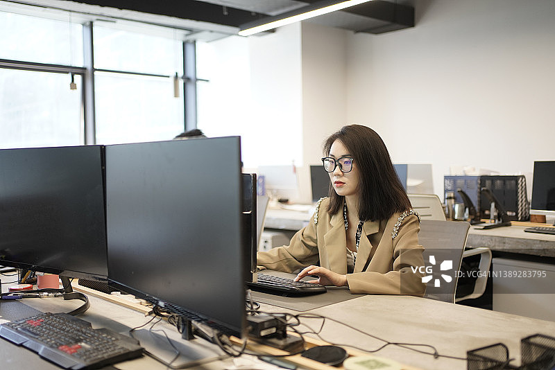 亚洲年轻女性在办公室工作图片素材