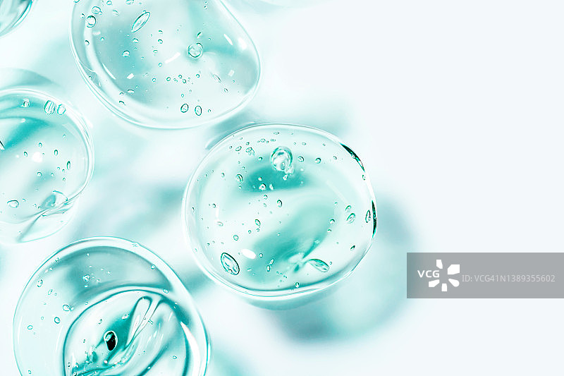 透明蓝色保湿精华液涂抹。 补水透明质酸。 带气泡的头发凝胶。 用于化妆和皮肤护理的化妆品。 美容。图片素材