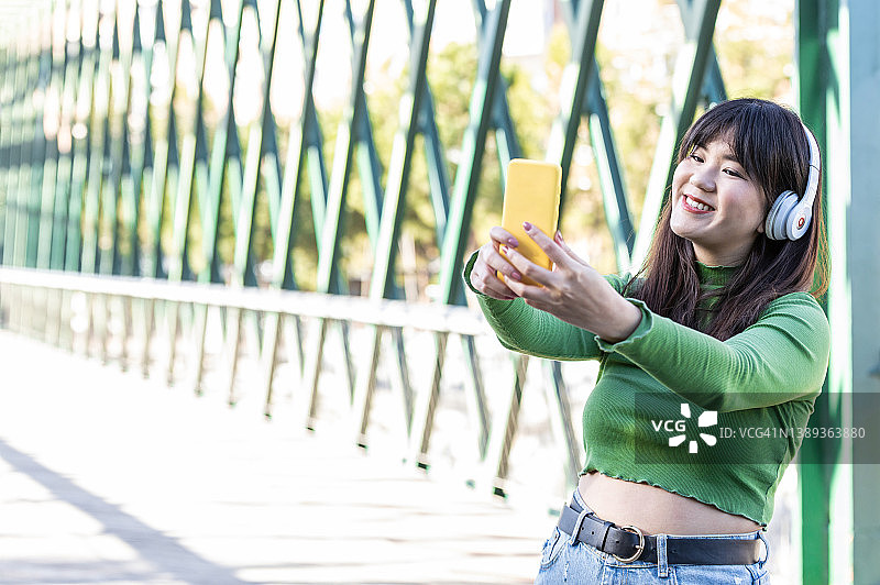 千禧一代女孩在城市街道上拍摄视频博客图片素材