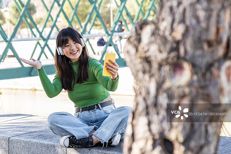 年轻女网红在欧洲旅行，用手机向粉丝展示她游览的地点图片素材