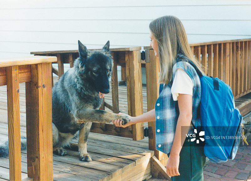 20世纪90年代的儿童与宠物狗在开学第一天（德国牧羊犬）图片素材