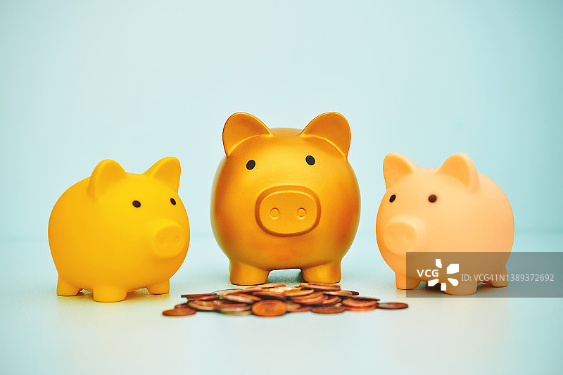 蓝色背景中的存钱罐家庭和一堆硬币图片素材