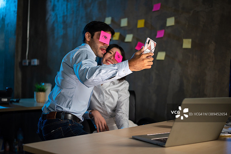 恶作剧：在朋友脸上放纸条并拍照图片素材