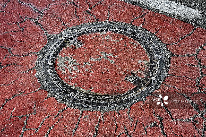 德国巴伐利亚肯普滕破裂沥青路面的沙井盖图片素材