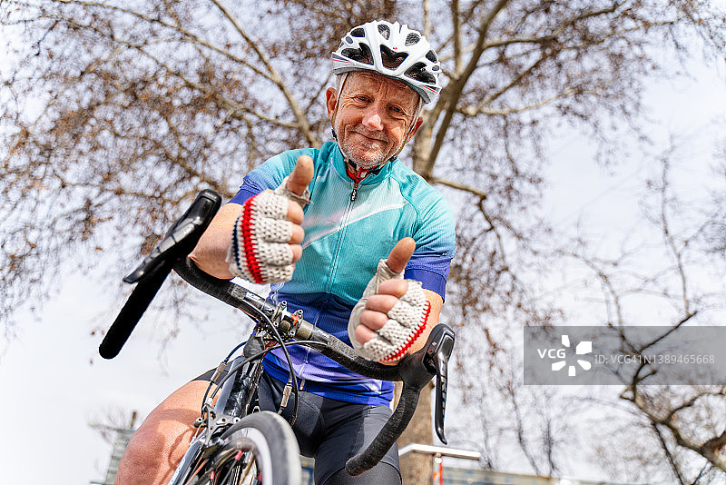 骑公路自行车，看着镜头的年长男人图片素材