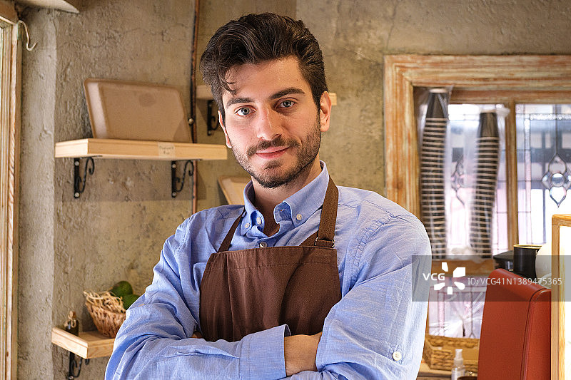 年轻咖啡馆店主交叉双臂的肖像图片素材