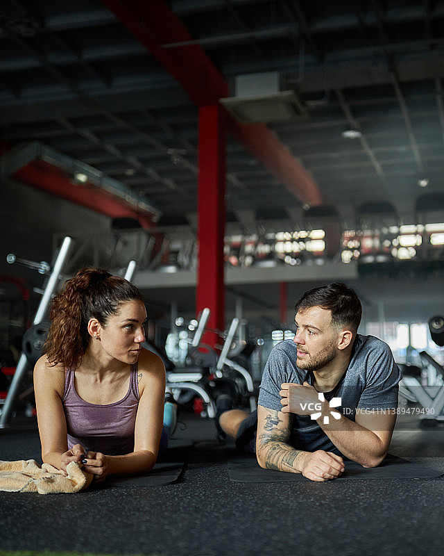 在健身房休息时交谈的运动情侣图片素材