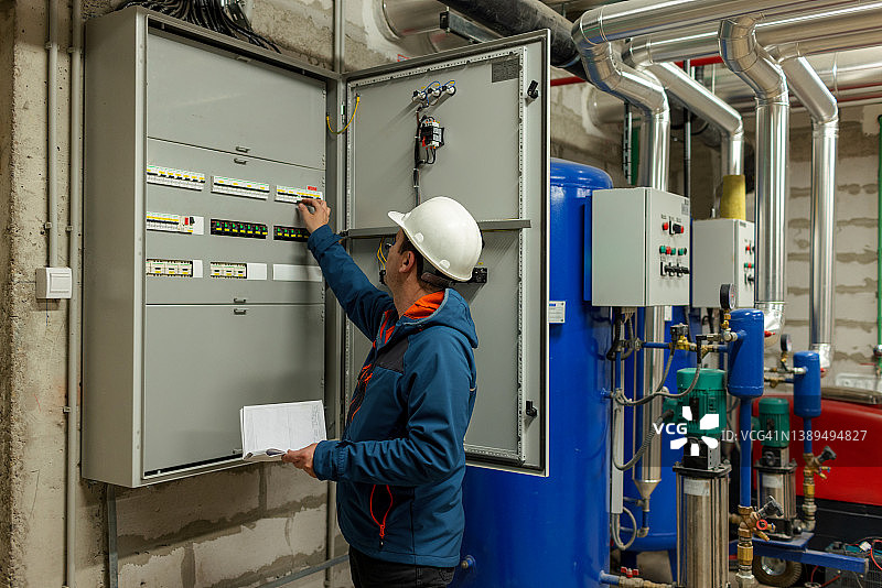 工程师在配电箱前检查方案图片素材