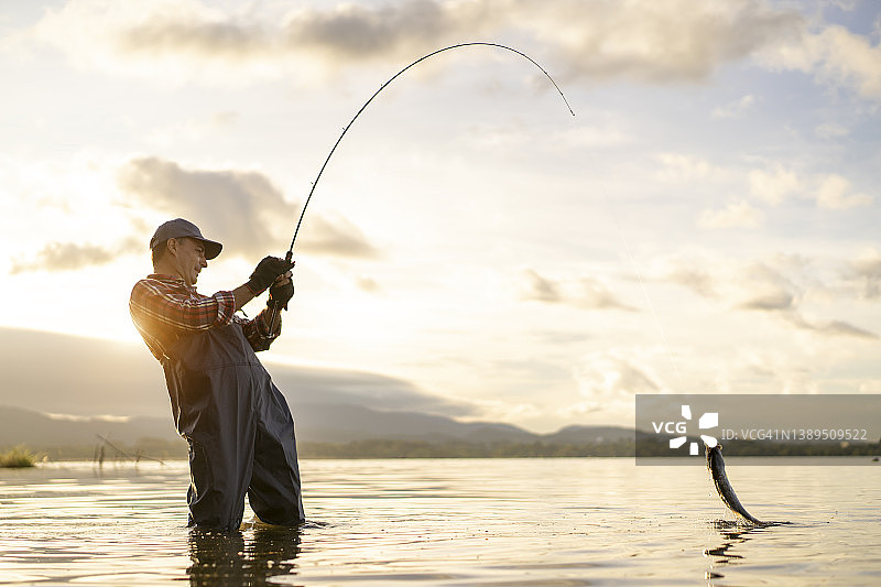 垂钓：年轻渔夫与战利品狗鱼图片素材