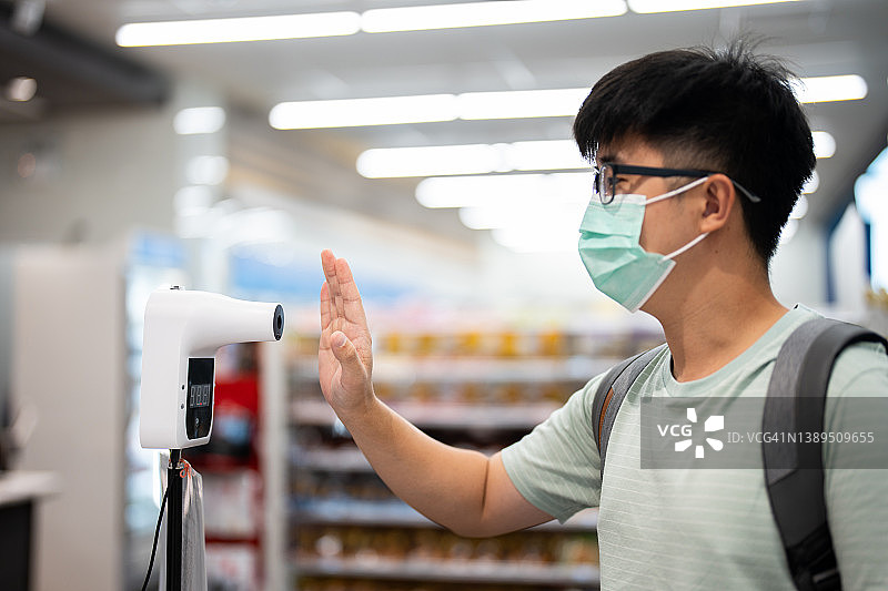 男人进商店前接受体温检查图片素材