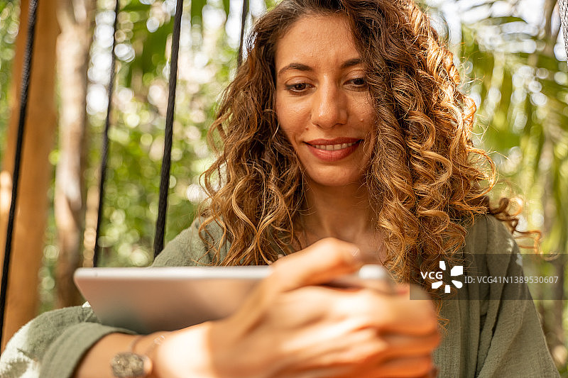 在户外咖啡馆使用平板电脑的多民族女人图片素材