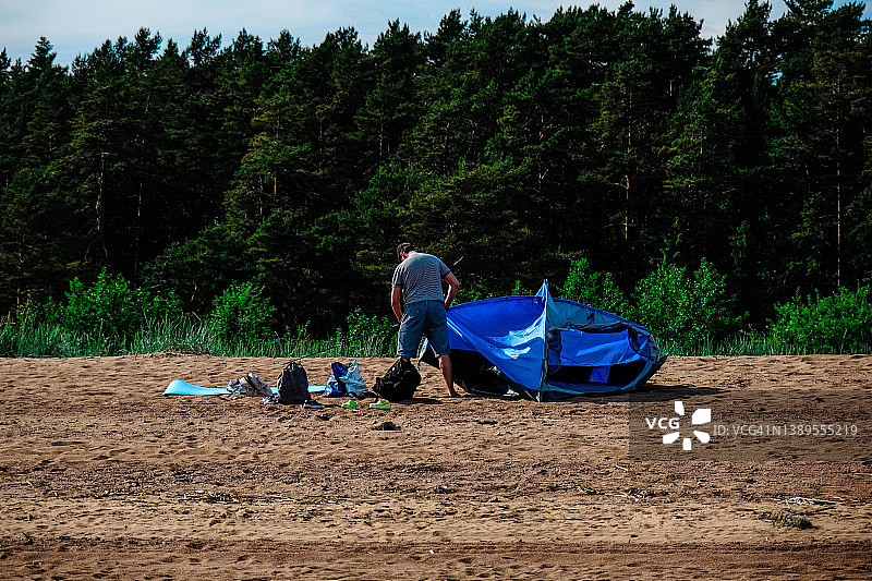 男人在海边搭建帐篷图片素材
