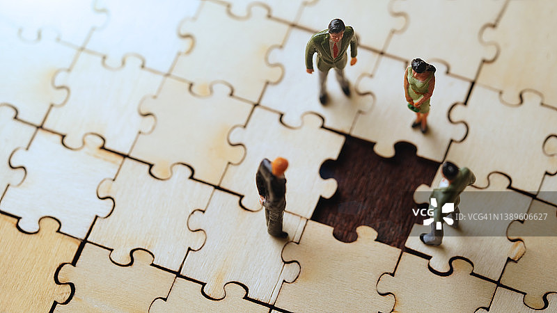 带有最后一块拼图概念照片的微型商业团队图片素材