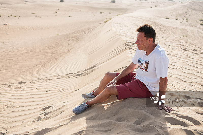 坐在沙漠中的老年男人图片素材