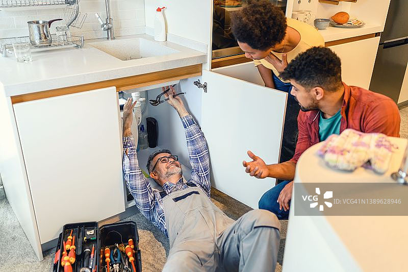 水管工修理厨房水槽图片素材