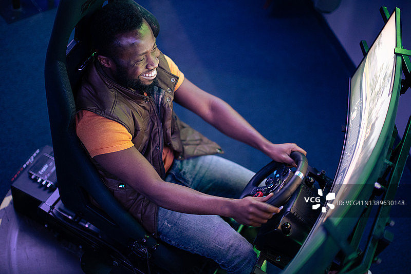 年轻男人玩在线赛车视频游戏图片素材