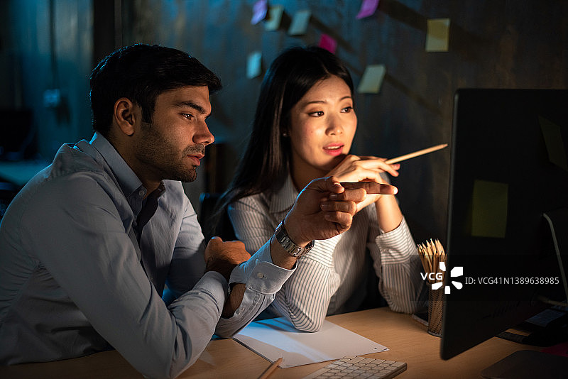两位亚洲男商人傍晚在办公室讨论一个项目图片素材