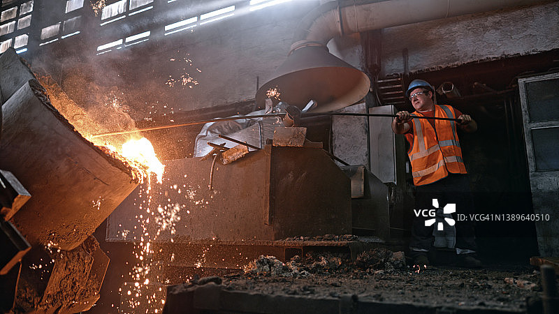 男人在铸造厂熔化金属图片素材
