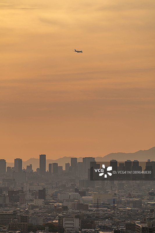 在日本大阪市上空飞行的飞机图片素材