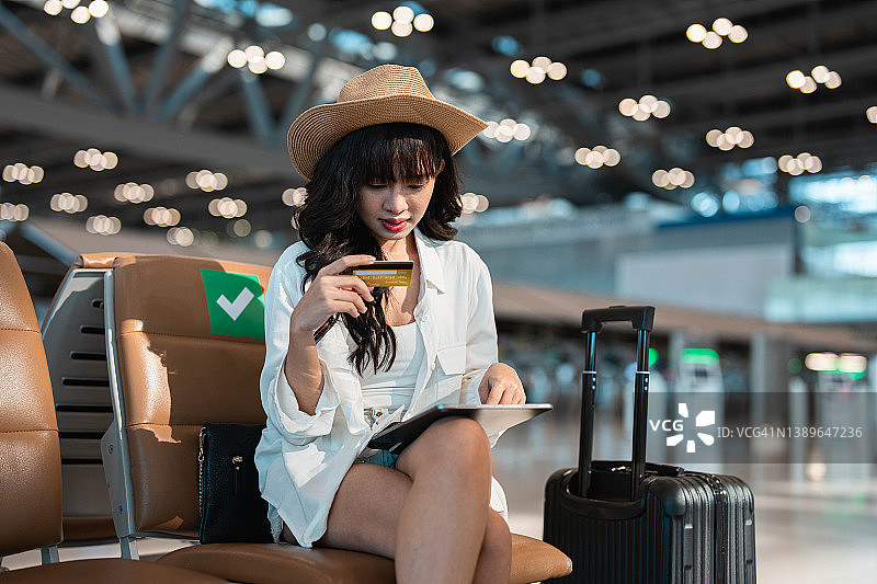 在机场用信用卡预订酒店/车辆的女游客图片素材