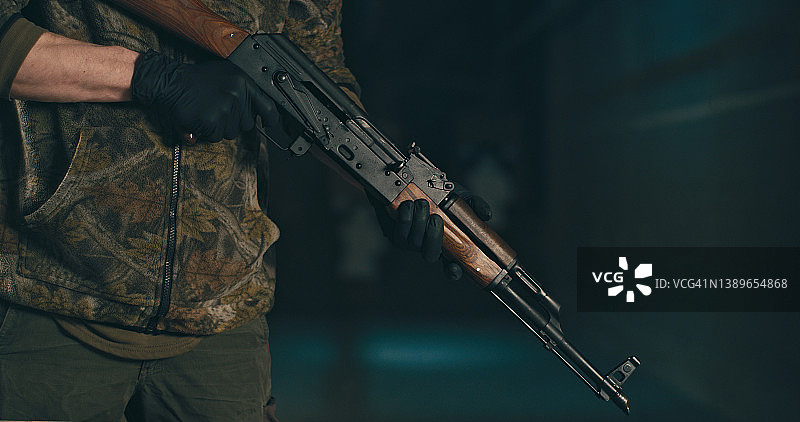 男人检查AK-47步枪，拆卸并准备使用图片素材