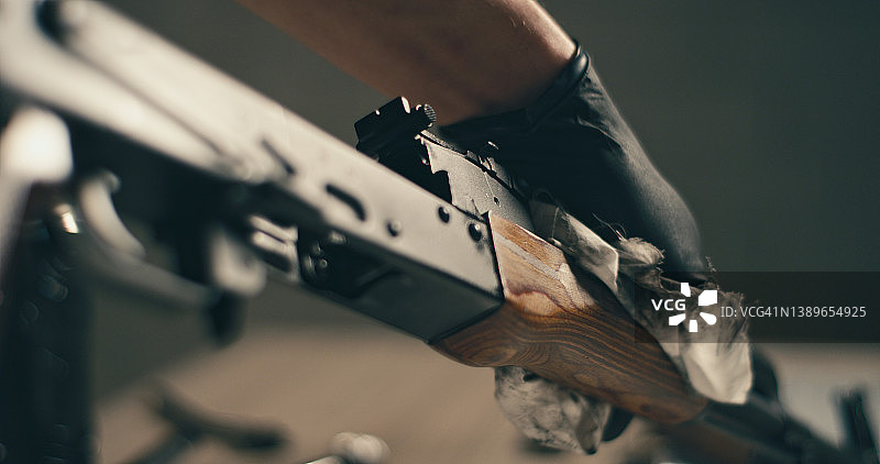 男人清洁AK-47步枪，拆卸并准备使用，手部特写图片素材