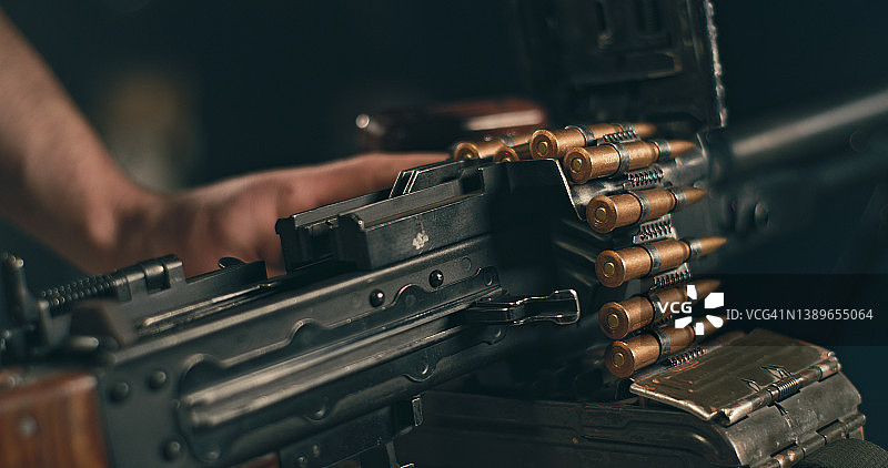 专业射击手装弹并准备使用重型PKM机枪图片素材