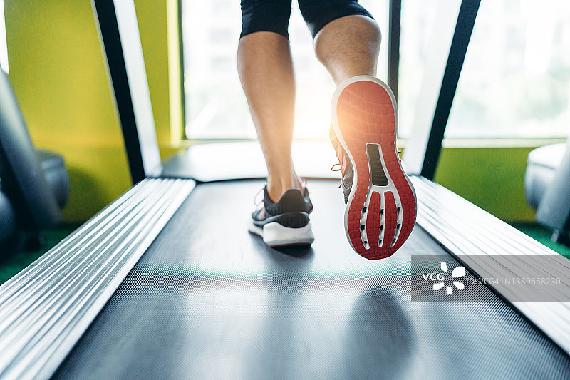 特写：在健身房跑步机上跑步的运动员。健康和健身概念图片素材