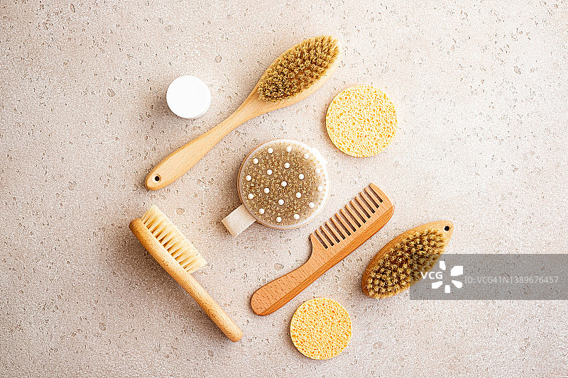 木制干性皮肤身体刷、清洁海绵、清洁手套特写，混凝土背景，选择性聚焦。家庭水疗，平铺。零浪费理念图片素材
