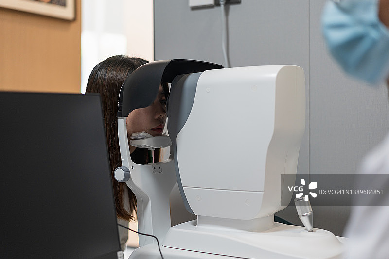 医生使用现代计算机仪器检查患者的眼睛图片素材