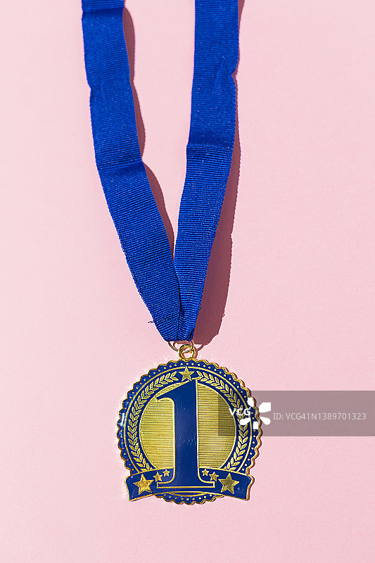 蓝色第一名奖牌，粉色背景上的竞赛获胜概念图片素材