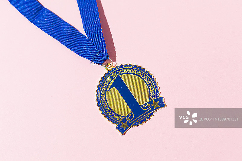 蓝色第一名奖牌，粉色背景上的竞赛获胜概念图片素材