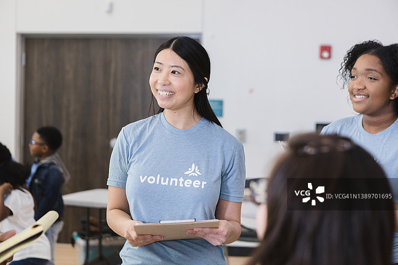 快乐的女社区活动主管听着看不见的人说话图片素材