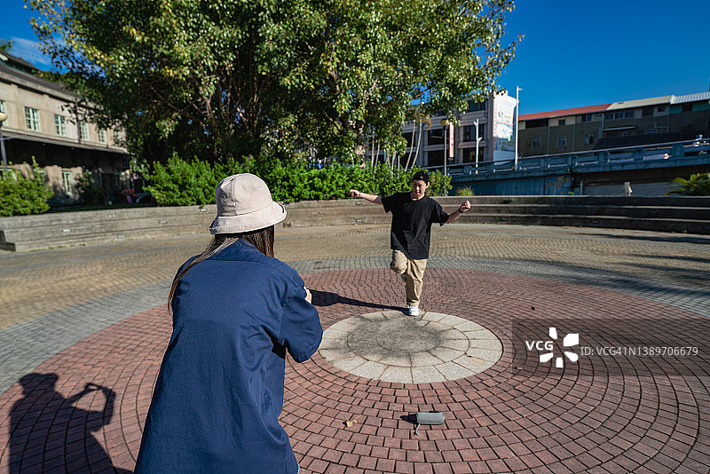 亚洲，台湾，两个年轻人在公园里跳舞和拍摄。图片素材