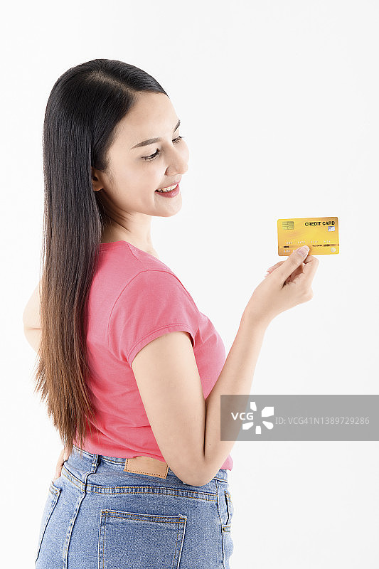 年轻女人拿着信用卡靠在白色背景上图片素材