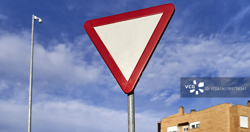 蓝色夏日天空下的倒白色三角形避让交通标志图片素材