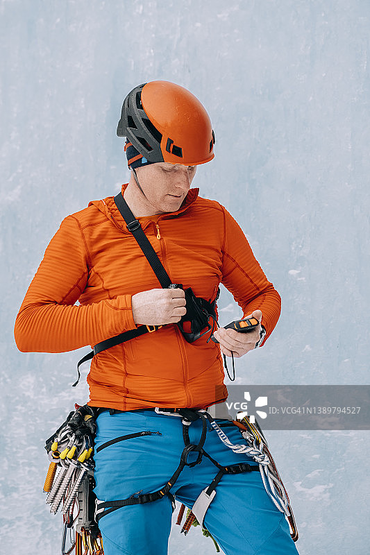 冰雪攀登者在攀登冰冻瀑布前测试雪崩收发器图片素材