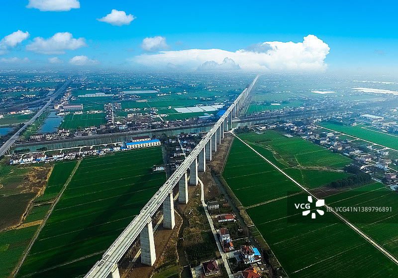 建设中的高速铁路桥梁横跨村庄和农田，江苏省江阴市图片素材