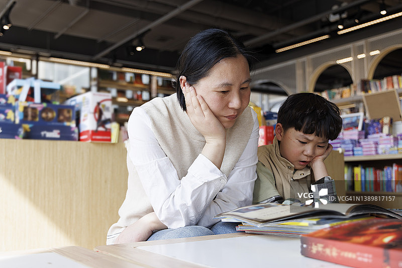 小男孩和母亲在图书馆里读书图片素材