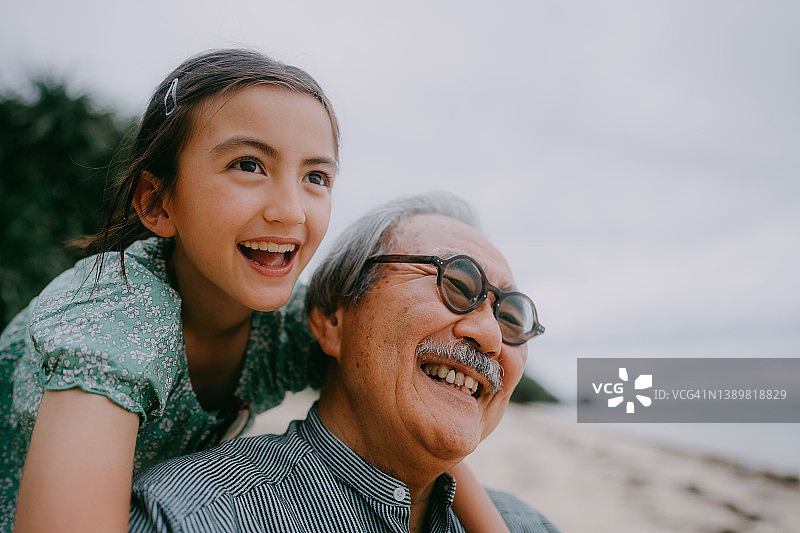 祖孙在黄昏时分的海滩上共享美好时光图片素材