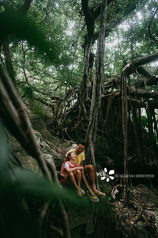 父亲和孩子在冲绳的丛林中与榕树，中国日本图片素材