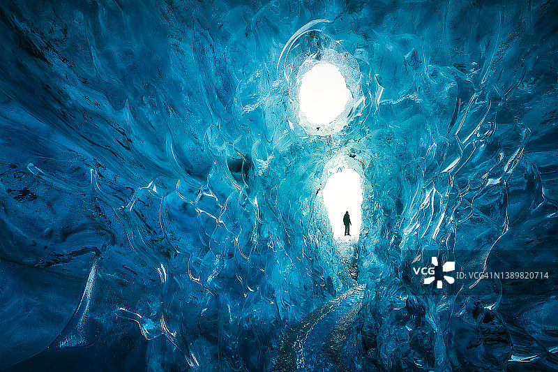 男人在冰岛瓦特纳冰川冰洞探险图片素材
