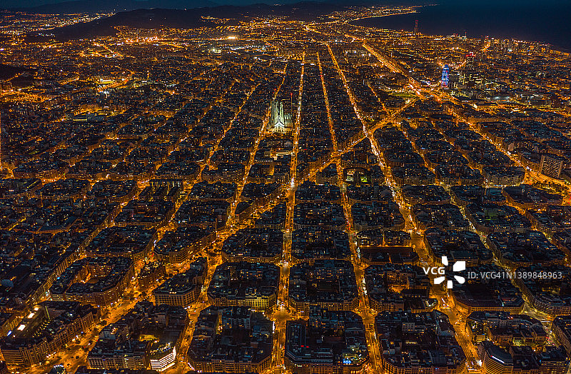 西班牙加泰罗尼亚巴塞罗那Eixample住宅区和圣家堂夜景航拍图片素材