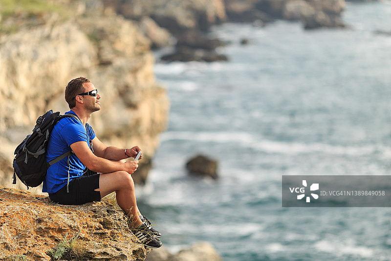 男子站在海边的岩石上图片素材