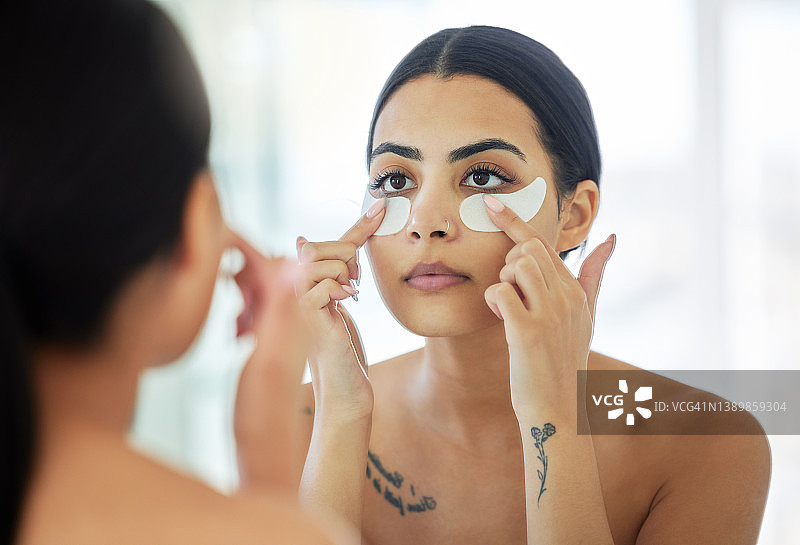 年轻女子在家中浴室使用眼膜图片素材