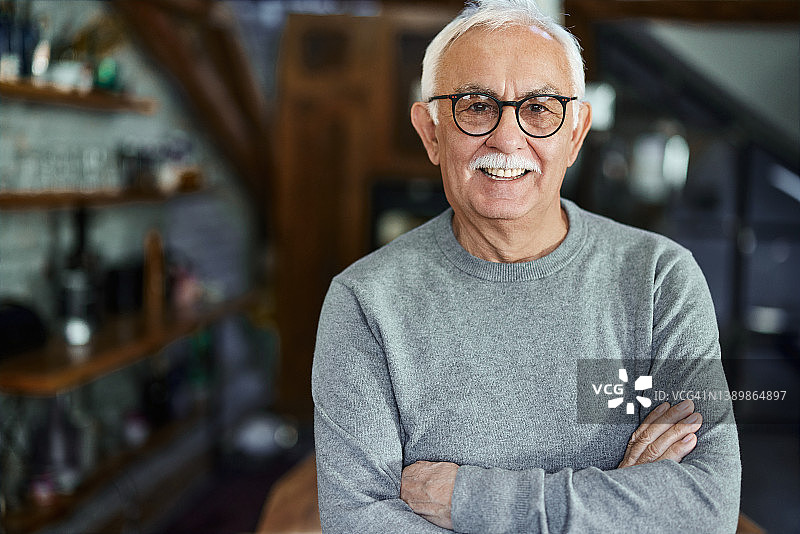 在家中双臂交叉的快乐老年男人图片素材